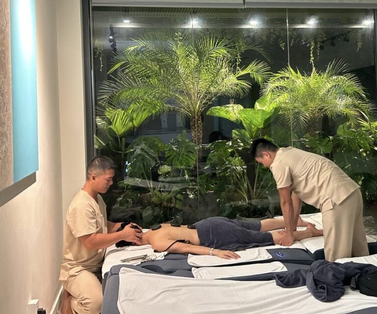 마사지실에서 두 남자가 한 여성을 마사지하고 있다